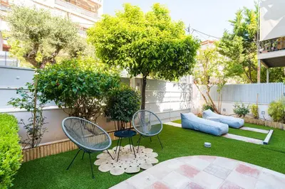 a small garden with two chairs and a table at BAMBOO Athens Villa in Athens