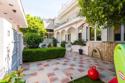 a courtyard of a house with a red vase at BAMBOO Athens Villa in Athens