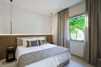 a bedroom with a large bed and a large window at BAMBOO Athens Villa in Athens