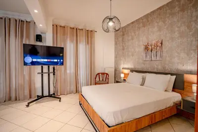 a bedroom with a bed and a flat screen tv at Flisvos Halcyon in Athens