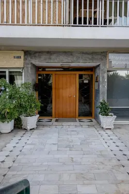 a front door of a building with two potted plants at Flisvos Halcyon in Athens