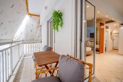 a balcony with a wooden table and chairs at Flisvos Halcyon in Athens