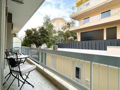 a chair sitting on the balcony of a house at Restful Flat in Glyfada Center in Athens