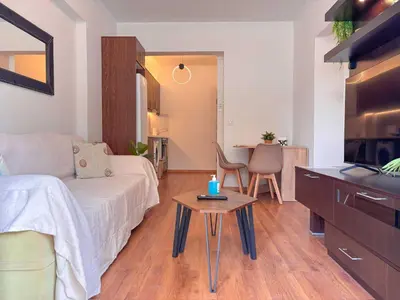a living room with a bed and a table at Restful Flat in Glyfada Center in Athens