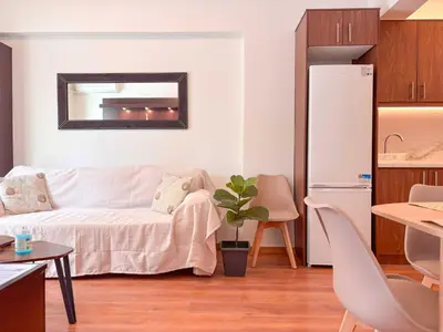 a living room with a white couch and a mirror at Restful Flat in Glyfada Center in Athens
