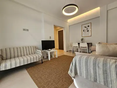 a living room with a couch and a tv at OLYMPIC Perfect Base to Explore Athens, Central Penthouse near metro and train in Athens