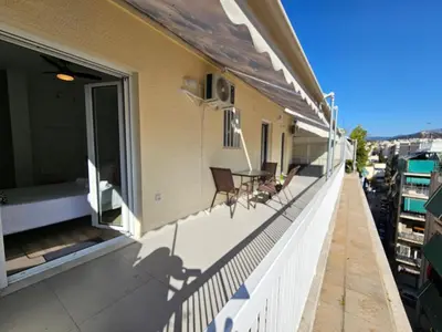 a balcony with chairs and a table on a building at OLYMPIC Perfect Base to Explore Athens, Central Penthouse near metro and train in Athens