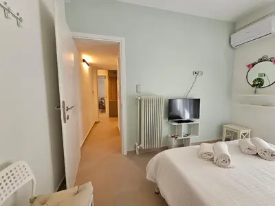 a white bedroom with a bed and a television at OLYMPIC Perfect Base to Explore Athens, Central Penthouse near metro and train in Athens