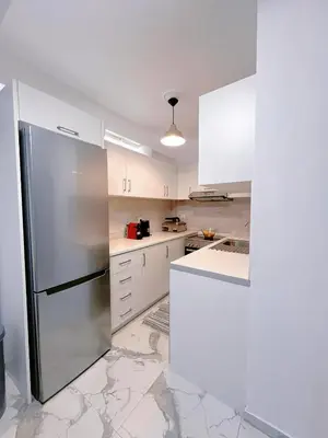 a kitchen with white cabinets and a stainless steel refrigerator at Varkiza Zen Space in Vari