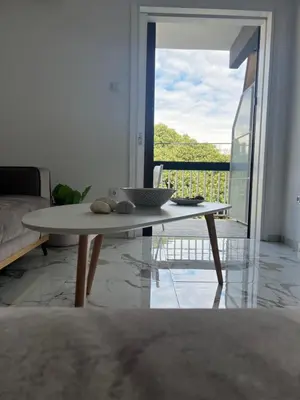 a coffee table in a living room with a balcony at Varkiza Zen Space in Vari
