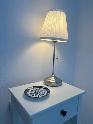 a lamp on a table with a plate on it at Varkiza Zen Space in Vari