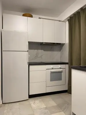 a kitchen with white cabinets and a white refrigerator at 2' from Beach Cozy & Renovated Maisonette in Porto Rafti