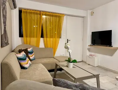 a living room with two couches and a tv at 2' from Beach Cozy & Renovated Maisonette in Porto Rafti