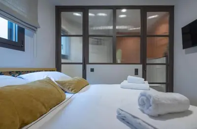 a bedroom with a white bed with towels on it at Ilisia Home in Athens