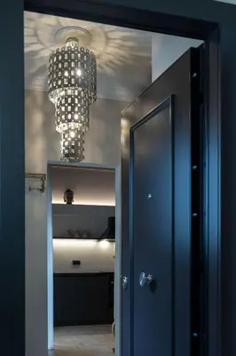 a hallway with a blue door and a chandelier at Ilisia Home in Athens
