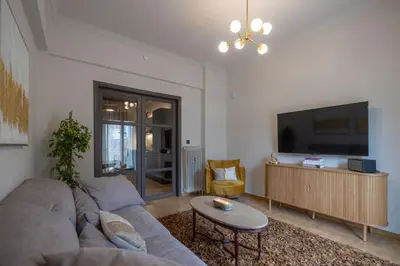 a living room with a couch and a flat screen tv at Ilisia Home in Athens