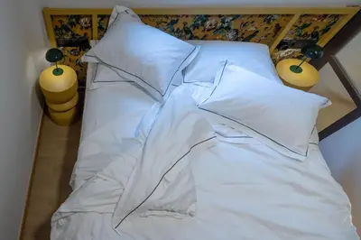 a bed with white sheets and pillows at Ilisia Home in Athens
