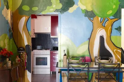 a kitchen with a tree painted on the wall at Funky Apartment in Athens