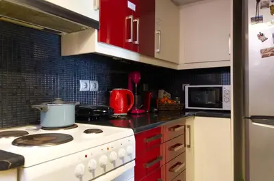 a kitchen with a white stove and red cabinets at Funky Apartment in Athens