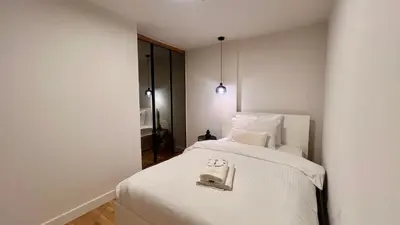 a bedroom with a white bed with a towel on it at The First by 22 in Piraeus