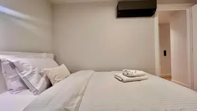 a white bed with two towels sitting on it at The First by 22 in Piraeus