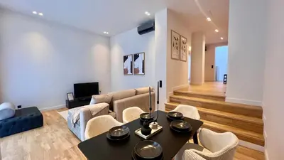 a living room with a couch and a table and chairs at The First by 22 in Piraeus