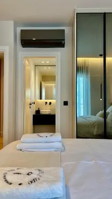 a bedroom with two beds and a large mirror at The First by 22 in Piraeus