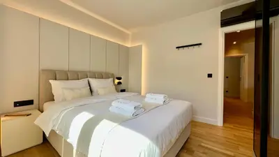 a bedroom with a large white bed with two towels on it at The First by 22 in Piraeus