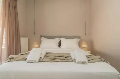a bed with white blankets and pillows on it at Elegant Suite Syntagma 2BR 2BA in Athens