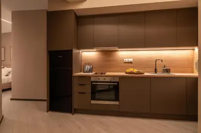 a kitchen with brown cabinets and a sink and a refrigerator at Elegant Suite Syntagma A2 in Athens