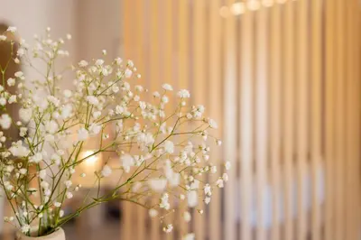 a vase filled with white flowers in front of a window at Elegant Suite Syntagma A2 in Athens