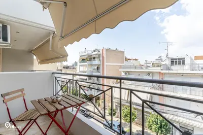 a balcony with a table and a view of a city at Suite Escape - Cozy House in Egaleo-Athens in Athens