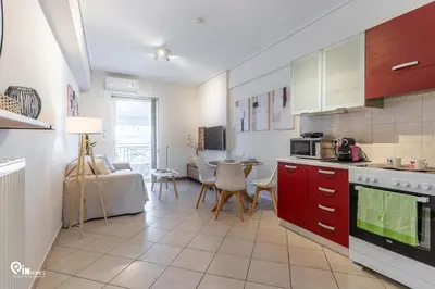 a kitchen with red cabinets and a table with chairs at Suite Escape - Cozy House in Egaleo-Athens in Athens