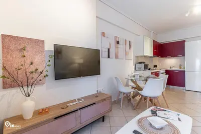 a living room with a flat screen tv on the wall at Suite Escape - Cozy House in Egaleo-Athens in Athens
