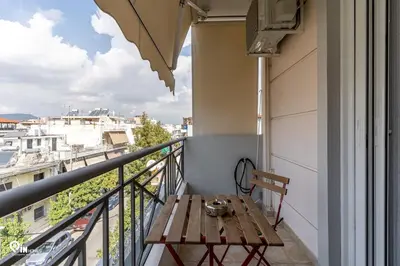 a wooden table on a balcony with a view at Suite Escape - Cozy House in Egaleo-Athens in Athens