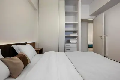 a bedroom with a large white bed and a closet at City & Sea in Athens