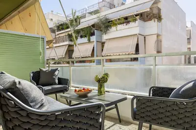 a balcony with chairs and a table and a building at City & Sea in Athens