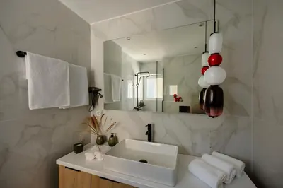 a bathroom with a white sink and a mirror at City & Sea in Athens