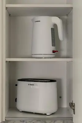 a white appliance sitting on shelves in a kitchen at City & Sea in Athens