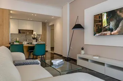 a living room with a couch and a table and a kitchen at City & Sea in Athens