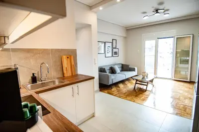 a kitchen with a sink and a living room with a couch at Olympian Zeus top location in Athens