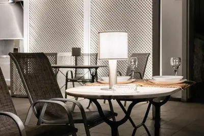 a dining room table with chairs and a lamp on it at The Acropolis Mansion in Athens