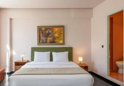 a bedroom with a large bed and a bathroom at The Acropolis Mansion in Athens