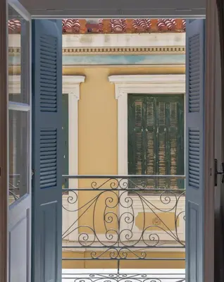 a balcony of a building with blue doors and a window at The Acropolis Mansion in Athens