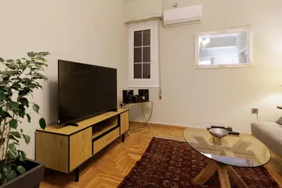 a living room with a large flat screen tv at Athens Koukaki Penthouse, Acropolis view in Athens