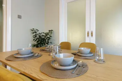 a wooden table with cups and saucers on it at Athens Koukaki Penthouse, Acropolis view in Athens