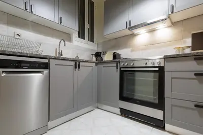 a kitchen with stainless steel appliances and white cabinets at Athens Koukaki Penthouse, Acropolis view in Athens