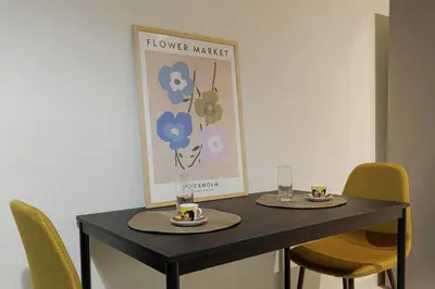 a black table with two plates and glasses on it at Athens Koukaki Penthouse, Acropolis view in Athens