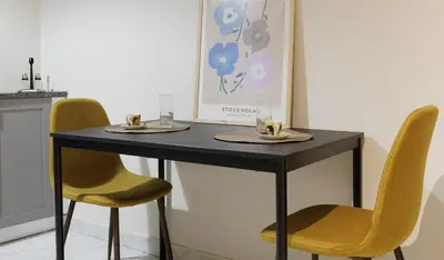 a black table with two chairs and two plates on it at Athens Koukaki Penthouse, Acropolis view in Athens