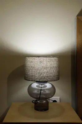 a lamp sitting on top of a wooden table at Athens Koukaki Penthouse, Acropolis view in Athens